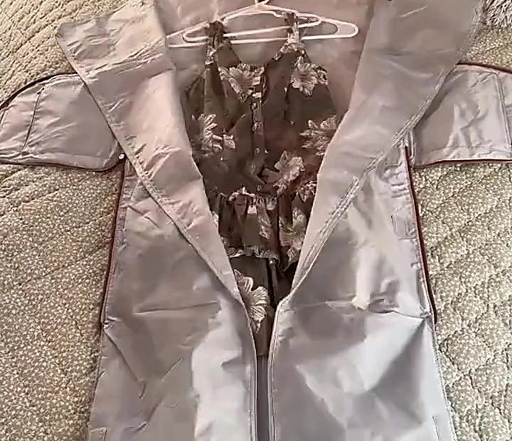 The garment compartment of the Luhxe Travel Bag laid flat with a dress hanging from the built-in hanger